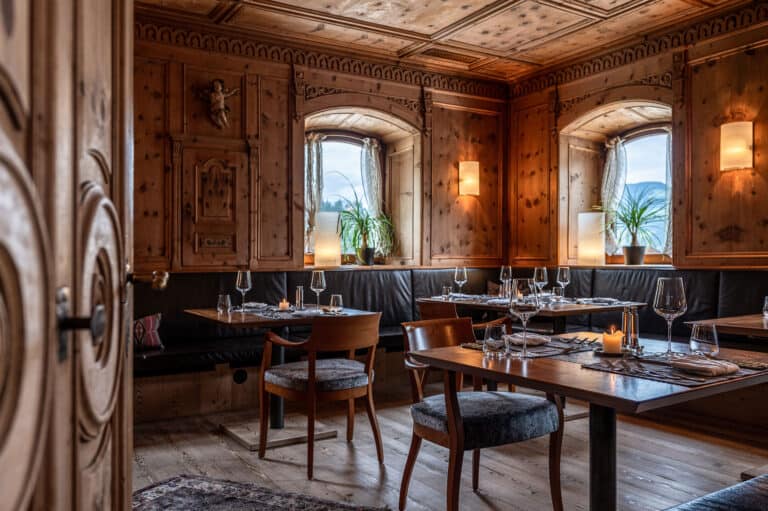 Helles Restaurant mit Holzvertäfelung, liebevoll gedeckter Tisch und stimmungsvolle Beleuchtung.
