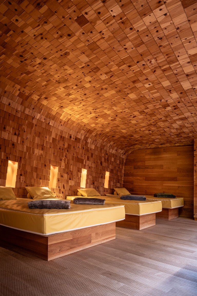 Entspannungsraum mit Holzdecke und Betten, ideal für Wellness und Erholung.