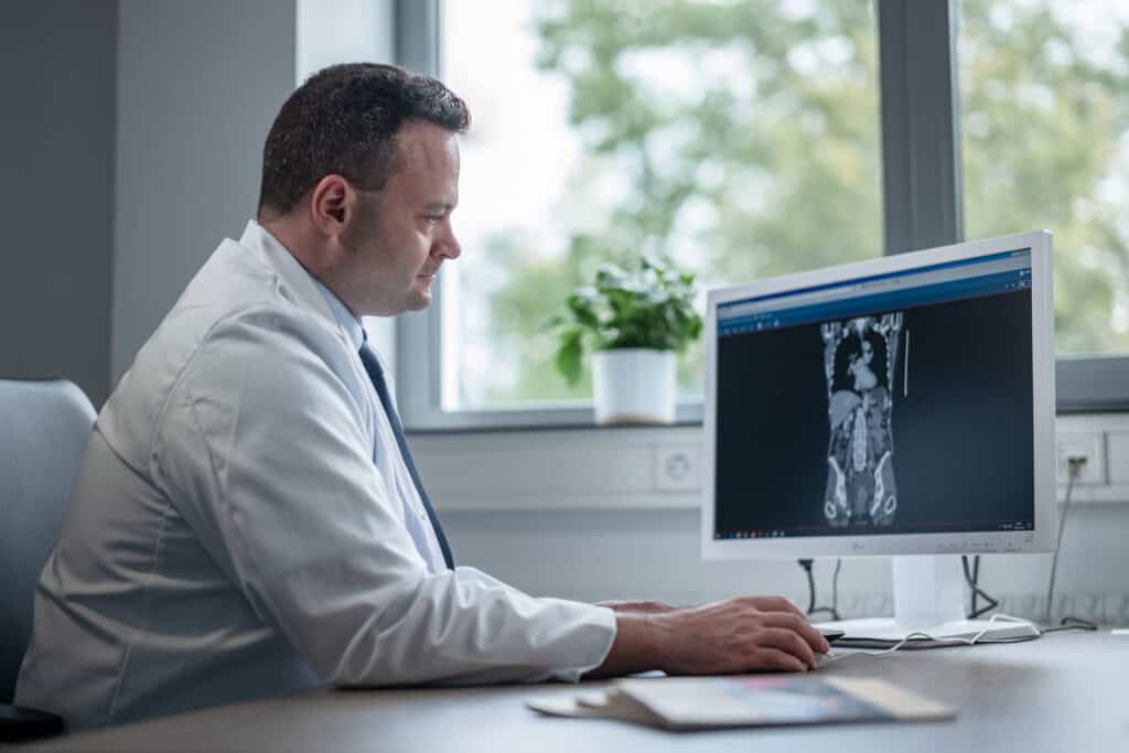 Arzt analysiert Röntgenaufnahme eines medizinischen Gebäudes und bildet sich seine Diagnose.
