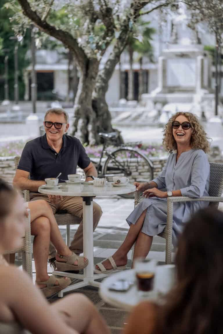 Kaffeetrinken im Freien, lachen, Geselligkeit, entspannte Atmosphäre.